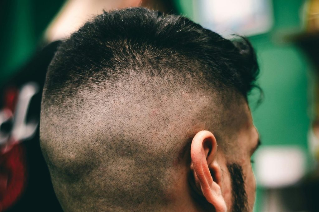 Rear view close-up of a man with a fresh haircut at a barbershop, showcasing a sharp fade.